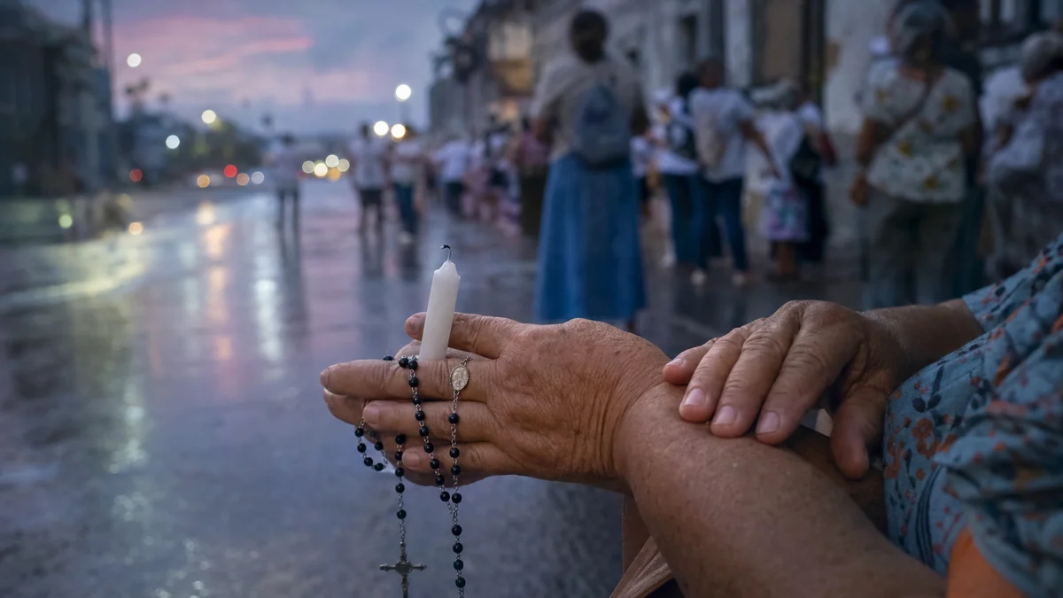 Mãos segurando um terço e uma vela em uma rua úmida ao amanhecer