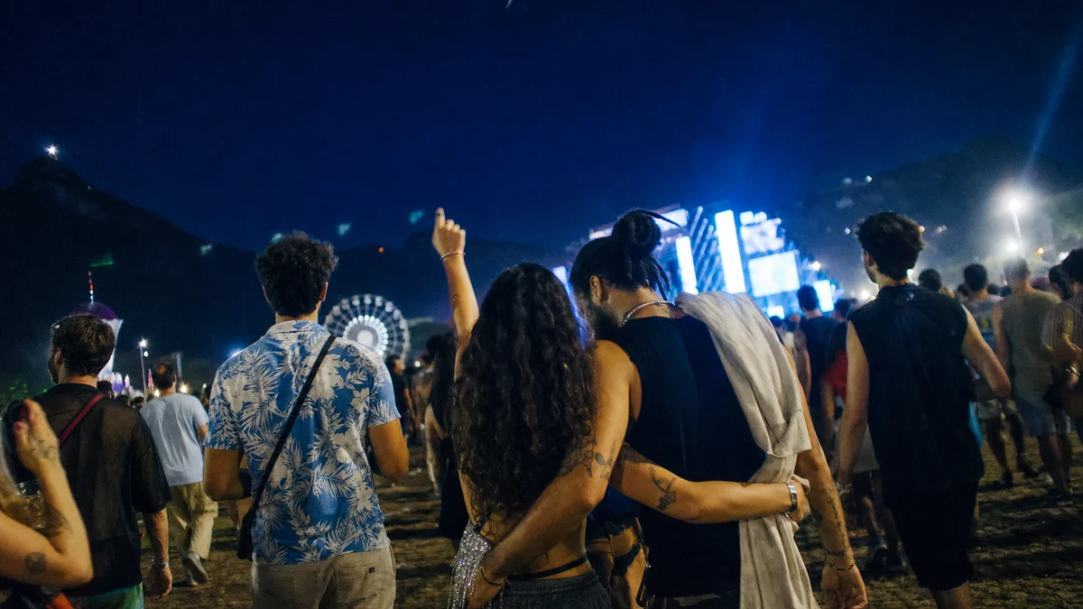 Grupo de amigos caminhando à noite em direção a um festival de música